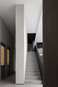 A modern interior featuring concrete stairs and dark walls.