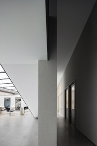 Contemporary office interior featuring minimalist design with concrete structural elements.