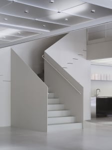 Minimalist modern interior featuring white walls and concrete stairs.