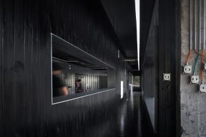 A modern, industrial-style office interior with exposed metal walls and pipes.