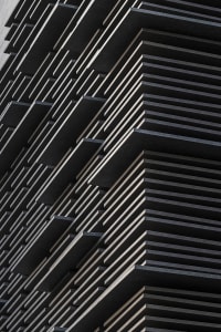 A close-up view of a modern building facade with black metallic panels.