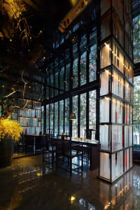 A modern restaurant interior with large glass windows and wooden furniture.