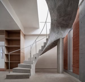 Concrete spiral staircase in an industrial interior setting.