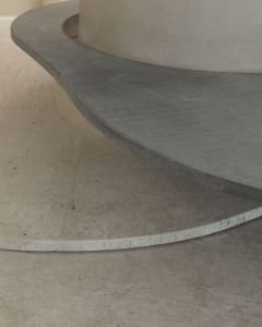 Close-up view of a minimalist interior space featuring concrete materials.
