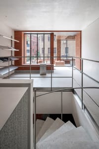 Modern staircase with brick walls, concrete steps, and aluminum handrails