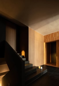 Modern staircase with concrete and stone material, featuring light and dark contrasts.
