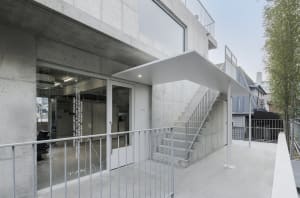 Concrete staircase and exterior building with large windows and steel railings.