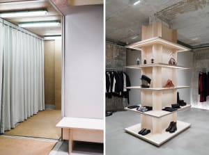 A modern retail space featuring a plywood display structure with illuminated shelves and racks.