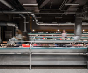 Modern storefront with steel barriers and industrial-style design.