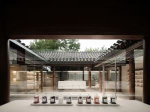A traditional tea room with concrete and glass windows, featuring a row of small jars in front of the entrance.