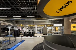 A modern fashion retail store with metallic finishes, concrete flooring, and glass displays.