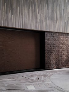 A textured, metal wall panel with a modern design in a contemporary interior space.