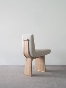 Modern contemporary dining chair made of wood with a tweed seat and brass accents.