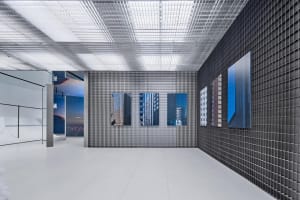 Modern art exhibition space featuring metallic grid walls and panels.