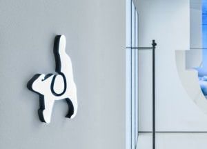 A minimalist metal icon mounted on a wall.