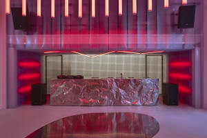 Modern event space featuring a metallic counter and red lighting.
