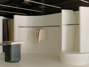 Minimalist retail store interior with smooth white surfaces and black marble accents