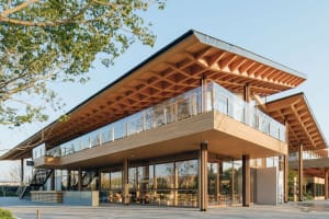 Modern building exterior with wooden beams and glass panels.