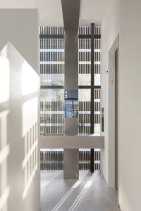 Modern corridor with concrete walls, floors, and columns.
