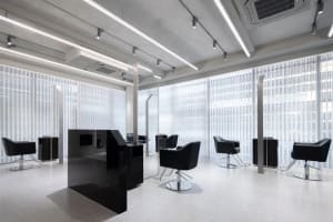 Modern salon interior with black metal chairs and glass dividers
