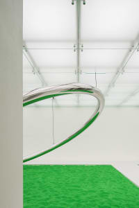 Polished metal sculpture in a minimalist, modern interior setting
