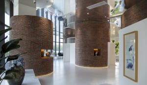A modern lobby with large brick columns and concrete flooring.