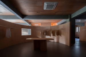 A modern interior design of a clothing store with wooden elements and minimalist aesthetics.