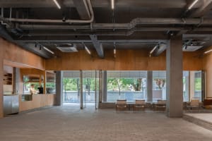 Industrial-style coffee shop interior featuring concrete, wood, and glass materials