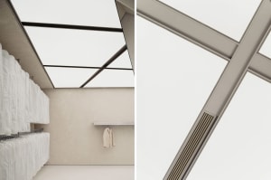 Minimalist clothing boutique interior with concrete walls, glass windows, and hanging suit jackets.