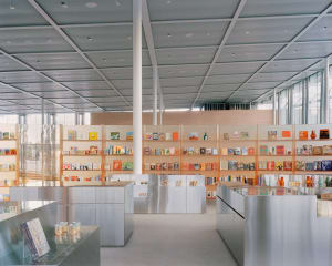 A modern bookstore with metal shelves displaying various books and products.