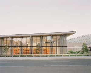 Modern office building with a glass façade reflecting an adjacent multi-story building.