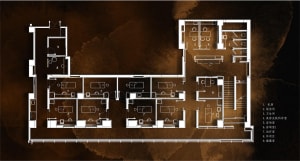 A hotel lobby with a spacious design featuring concrete, stone, and wood materials.