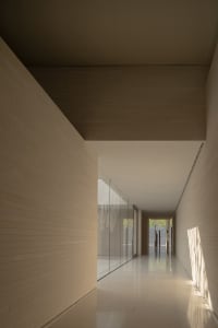 Modern interior featuring glass walls and concrete flooring in a corridor.