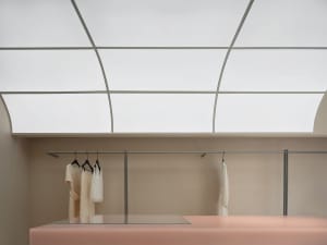 A modern minimalist fashion retail space features concrete and glass materials.