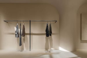 A minimalist clothing display featuring a hanging rack with clothes.