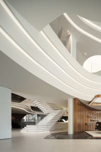 A modern architectural interior design showcasing sleek lines, curved walls, and a prominent staircase.