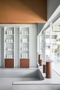A modern retail store with concrete shelves displaying products.
