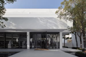 Modern minimalist storefront with large glass doors and white exterior.