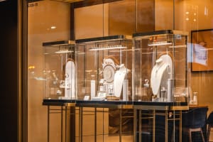 A modern retail jewelry display featuring glass cases with illuminated jewelry.