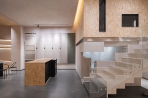 A modern showroom with industrial design features, showcasing concrete and OSB materials.