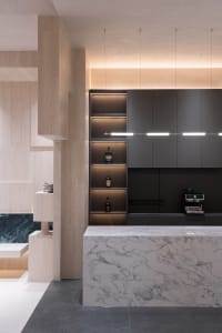 A modern kitchen featuring marble countertops and concrete surfaces.