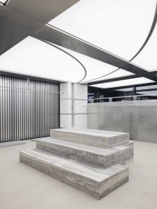 A modern industrial interior space featuring concrete steps and a minimalist design.