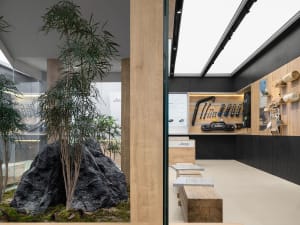 An industrial-themed automotive showroom featuring wood and concrete materials.