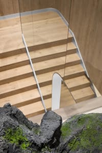 Modern indoor staircase with wooden steps and handrail.