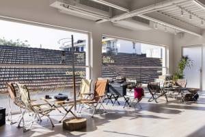 Modern, foldable chairs arranged on a wooden platform with outdoor elements in the background.