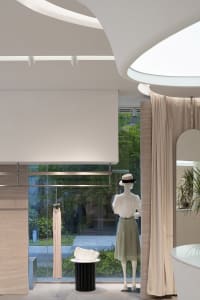 Minimalist storefront with glass window and clothing display.