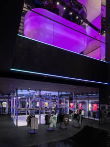 A minimalist retail space featuring metallic display stands and apparel.