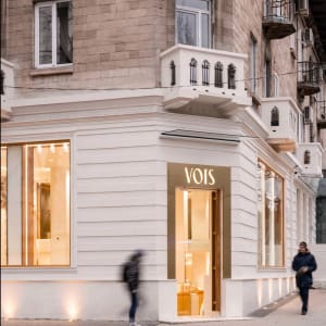 Modern retail storefront with large glass windows and illuminated signage.