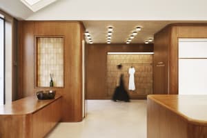 A modern minimalist shopping center with wooden cabinets, glass panels, and concrete flooring.