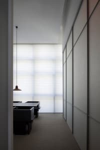 A minimalist office space with a white board and illuminated light.